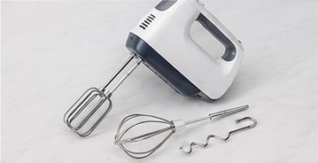 Weißer Handmixer mit Rührbesen und Knethaken daneben