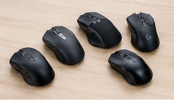 Sechs verschiedene Computermäuse nebeneinander auf einem Schreibtisch