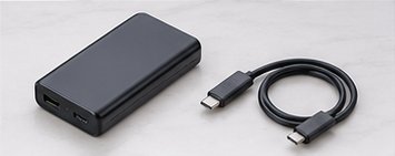 Schwarze Powerbank mit USB-C-Kabel auf weißem Untergrund