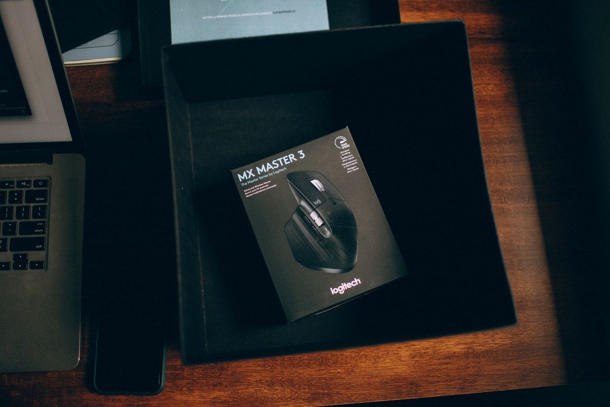 Verpackte kabellose Computermaus in einer geöffneten Box auf einem Schreibtisch
